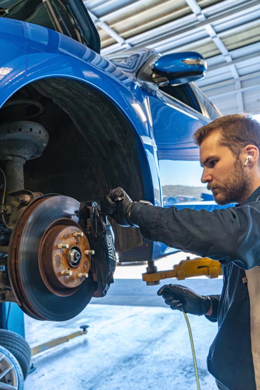 M45 Automotive technician performing brake service on a Subaru in Auburn, CA